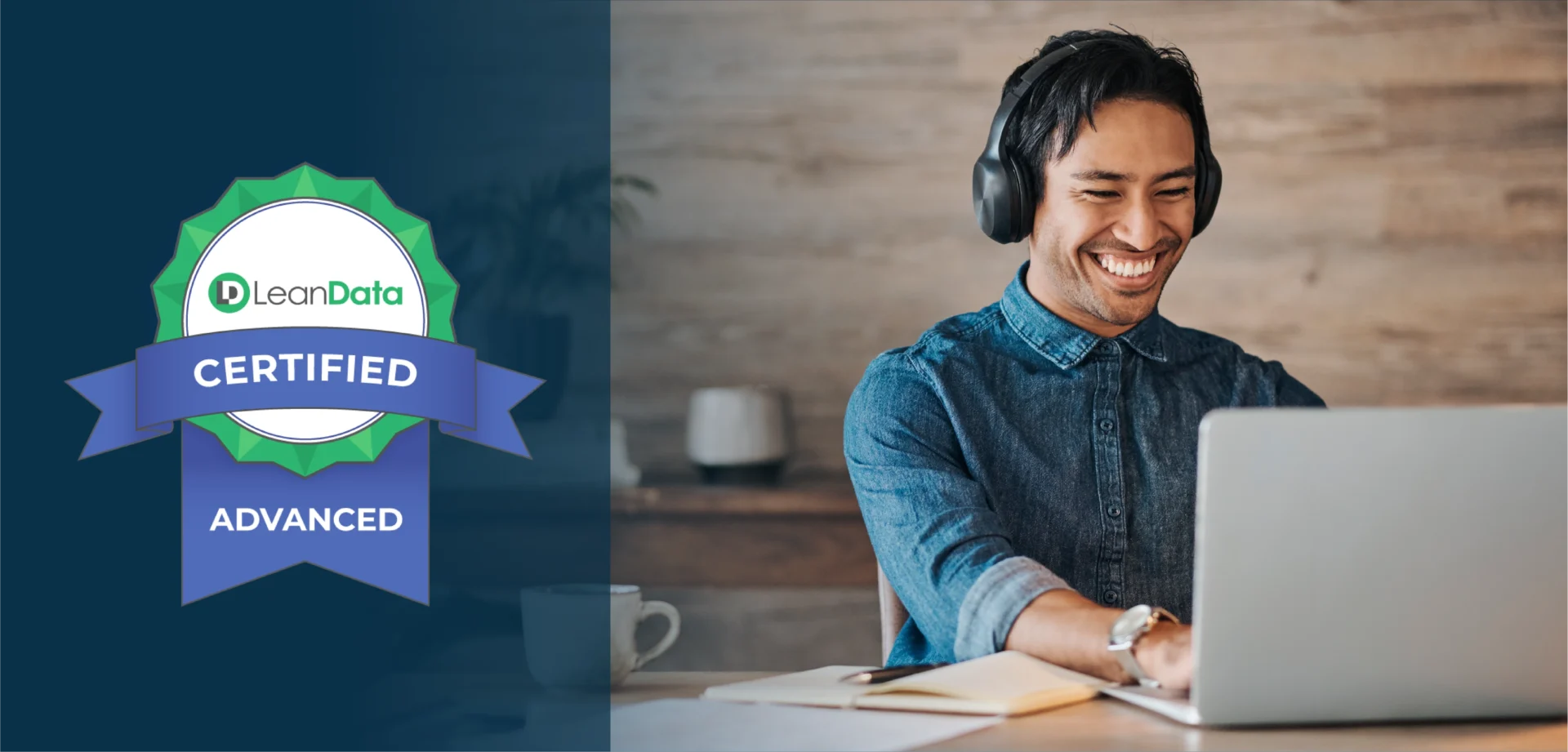 professional man smiling while wearing headphones and using a laptop at a desk